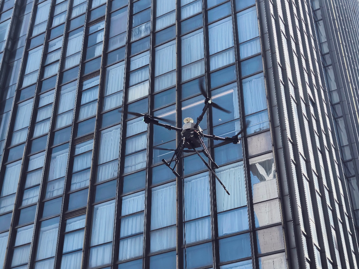 Professional drone window cleaning operation on high-rise building facade Professional drone window cleaning operation on high-rise building facade