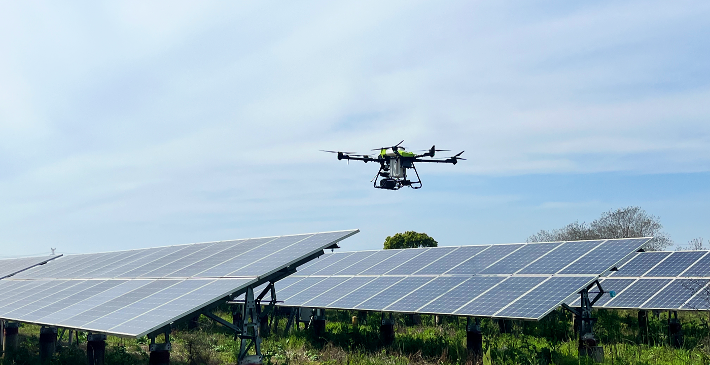  C40B drone cleaning solar panels on industrial rooftop array