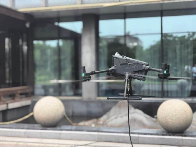 Drone window cleaning service in action – modern cleaning drone washing high-rise building glass