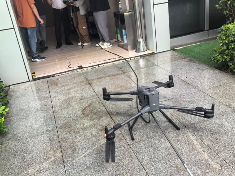 Drone window cleaning service in action – modern cleaning drone washing high-rise building glass