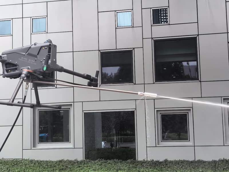 Drone window cleaning service in action – modern cleaning drone washing high-rise building glass