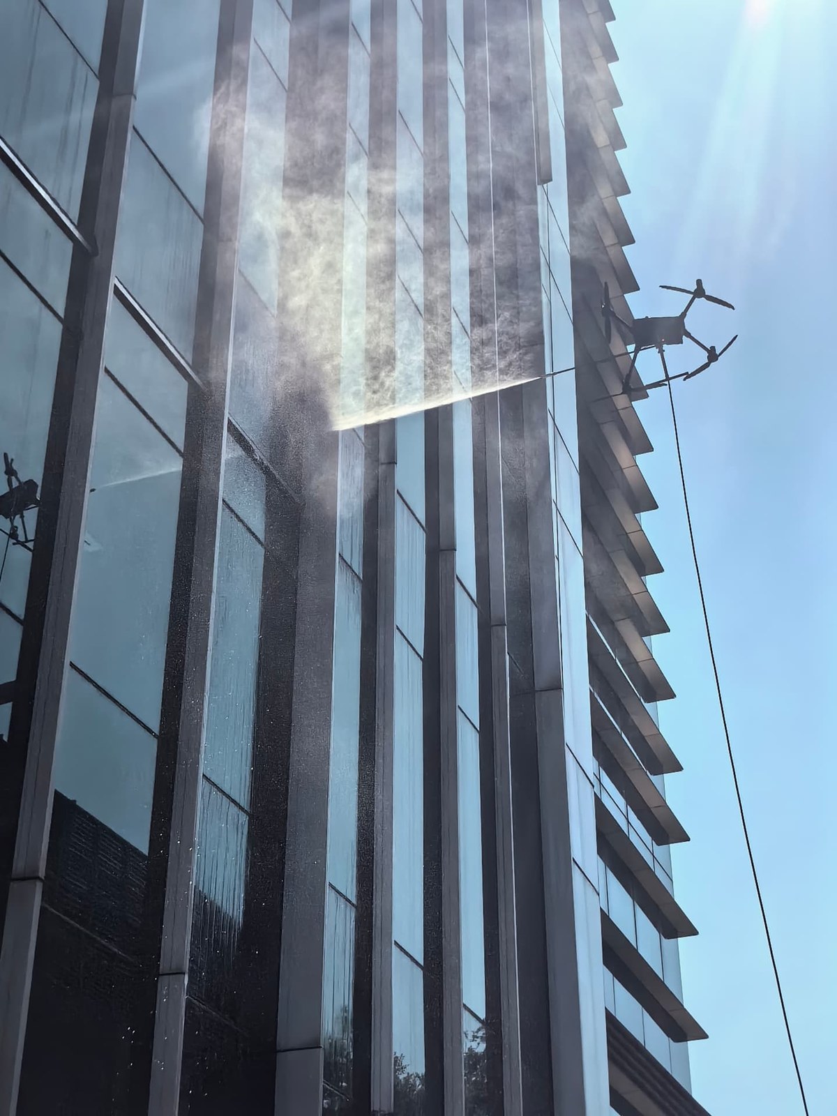 Aerial view of a glass curtain wall high-rise tower before drone facade cleaning Aerial view of a glass curtain wall high-rise tower before drone facade cleaning